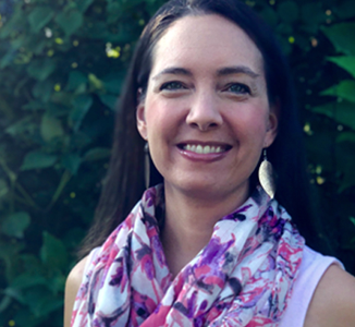 A headshot, taken by her daughter, depicts Jessica smiling and wearing a bright scarf outside.